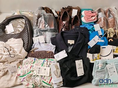 de nombreux sacs contenant des vêtements et des chaussures posés sur une table