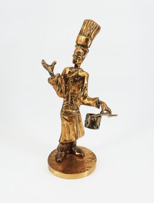 figurine en or représentant un homme coiffé d'un chapeau et tenant un seau