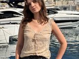 une femme debout devant un bateau sur l'eau