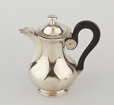 a silver coffee pot with a black handle on a white surface
