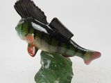 statue of a fish on a rock on a white background