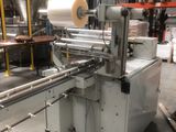 une photo d'une machine sur laquelle est posé un rouleau de papier, dans un entrepôt