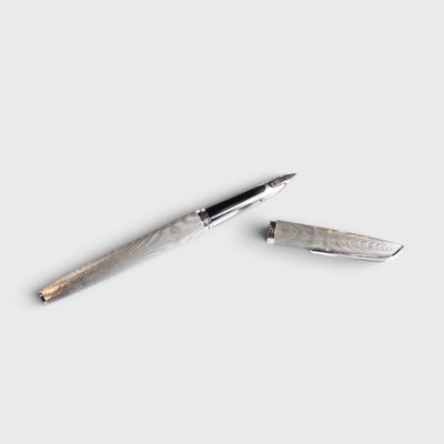 a pen and a knife laying on a white surface