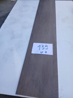 Dans un entrepôt, des planches de bois sont empilées les unes sur les autres.