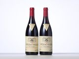 two bottles of red wine sitting on top of a table