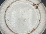 a white plate with a brown rim sitting on a table