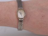 a woman ' s wrist that has a watch on it