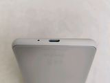 a close up of the back of a white phone on a white surface