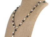 Le collier est orné de perles et d'une longue chaîne.