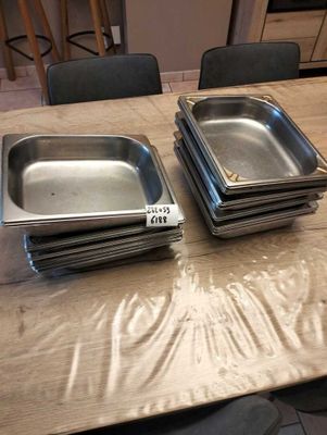 several trays of food are sitting on a table in a kitchen