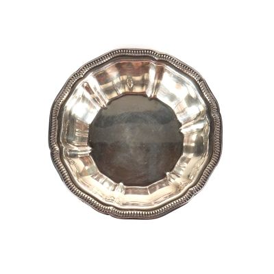 une assiette en argent sur fond blanc avec un fond noir