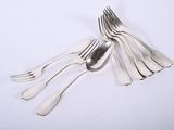 five forks and two spoons on a white surface