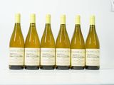 six bouteilles de vin sont alignées sur une table