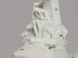 sculpture représentant une formation rocheuse sur laquelle est assis un homme