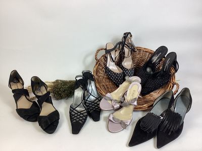 several pairs of black shoes sitting on top of a wicker basket
