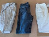 three pairs of jeans are laid out on a cardboard box