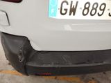 the rear end of a white car with a number plate on it ' s bumper