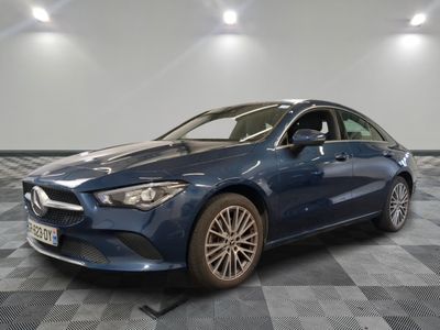 a blue mercedes cla parked in a garage with a checkered floor