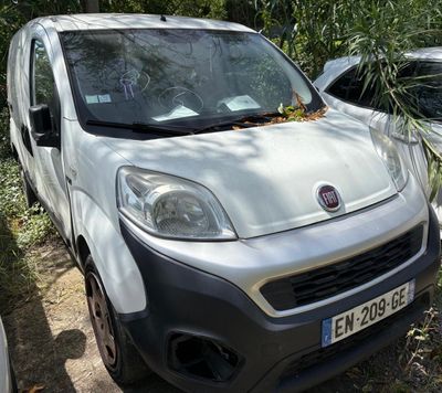 une petite camionnette blanche garée à côté d'une voiture