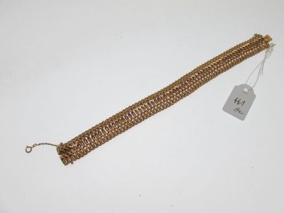Gros plan sur un bracelet en or portant une étiquette
