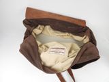 brown leather purse with a label on it sitting on a white surface