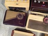 four old radio ' s sitting on the floor next to each other
