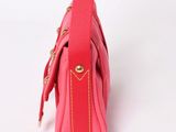 a close up of a pink purse on a white surface