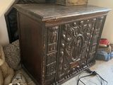 a teddy bear sitting next to a chest in a room