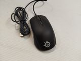 a black computer mouse sitting on a white surface