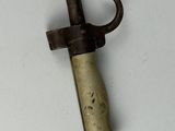 a small metal object with a wooden handle on a white surface