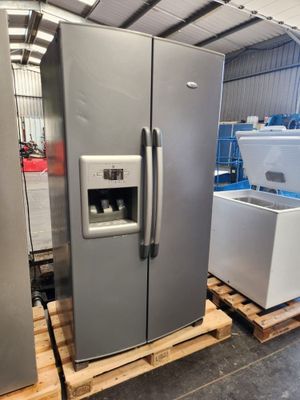 two refrigerators that are sitting on pallets in a warehouse