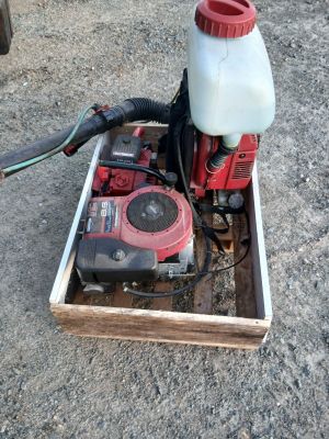 une pompe à eau rouge et blanche posée sur une caisse en bois
