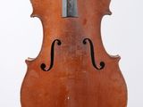 un vieux violon suspendu à une ficelle sur un mur blanc