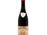 an old bottle of wine sitting on top of a white surface