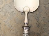 a silver spoon with a white handle on a marble table