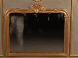 a mirror with a gold frame on the wall
