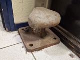 a stone stool sitting on the floor in front of a door