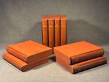 quatre livres orange empilés les uns sur les autres sur une table
