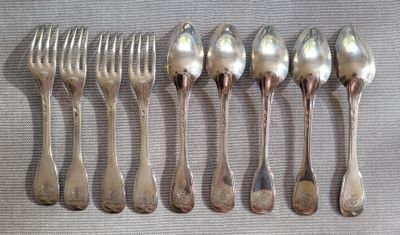 six cuillères et une fourchette sont alignées sur une table