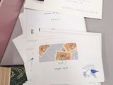 many mails sitting on a table next to a pink box