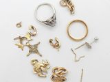 a group of various rings and earrings on a white surface