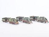 several toy trains are lined up in a row on a white surface