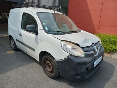 une camionnette blanche endommagée, garée devant un immeuble