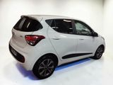 the rear end of a small white car in a white room