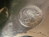 a silver plate with a silver coin on it