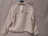 a close up of a sweater hanging on a hanger on a wall