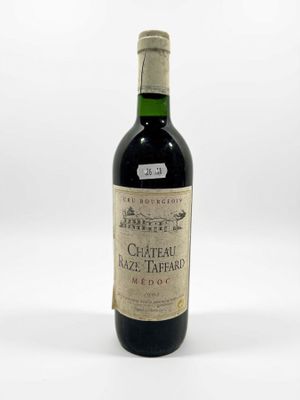 une vieille bouteille de vin posée sur une table blanche