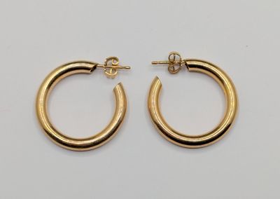 a pair of gold hoop earrings on a white background