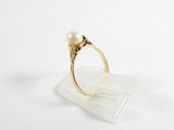 a close up of a gold ring with a pearl in it