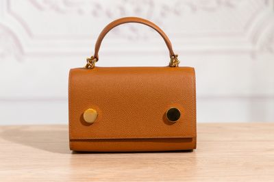 un petit sac à main marron posé sur une table en bois